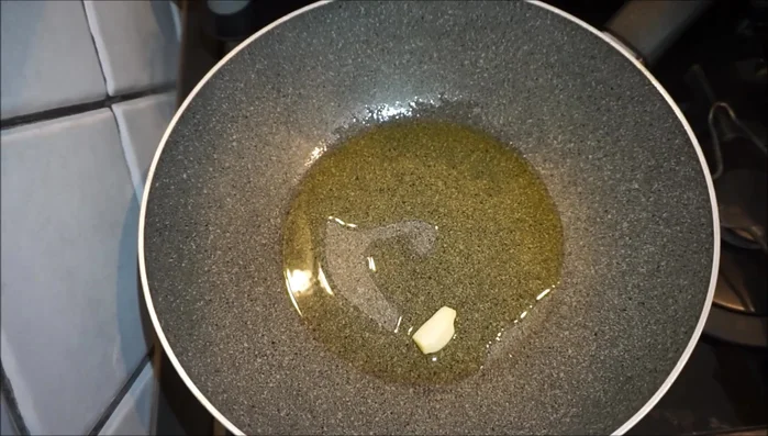 In una padella, riscaldare l'olio extravergine d'oliva con uno spicchio d'aglio.