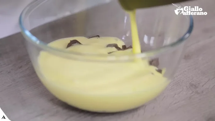 Aggiungere il cioccolato tritato alla crema calda e mescolare fino ad ottenere una crema liscia e lucida.