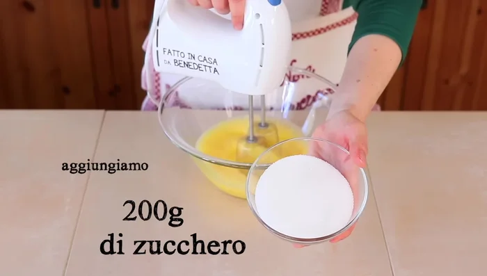 Aggiungi le carote grattugiate al composto di uova, zucchero e olio. Mescola bene.