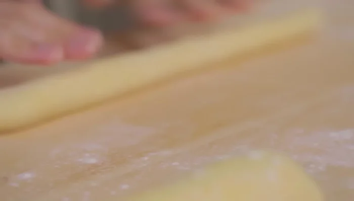Formare gli gnocchi: ricavare dei rotolini dal panetto, tagliarli a pezzetti e passarli sulla spianatoia infarinata (145.91).