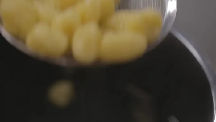 Condire gli gnocchi: scolare gli gnocchi e aggiungerli al sugo (206.17).