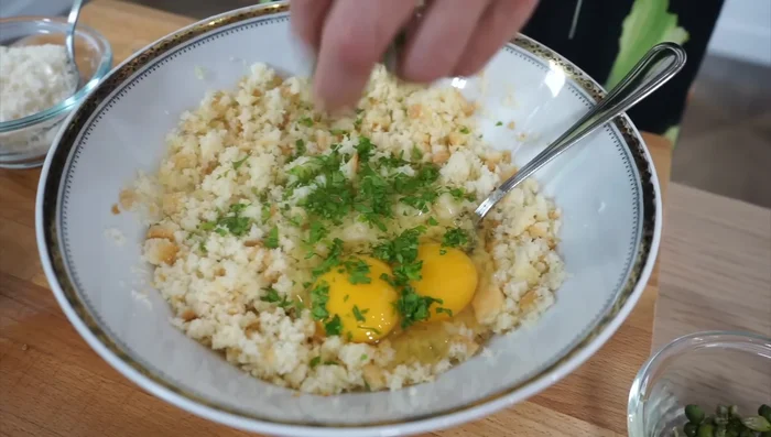 In una ciotola, unire il pane, le uova, il prezzemolo, i capperi, le olive, i pomodori, il pecorino, 2 cucchiai di olio, pepe e poco sale.