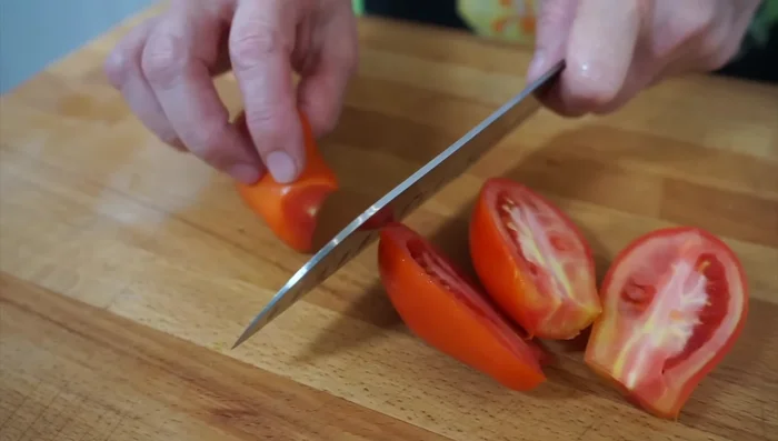 Tagliare i pomodori a pezzi molto piccoli e la scamorza a cubetti.
