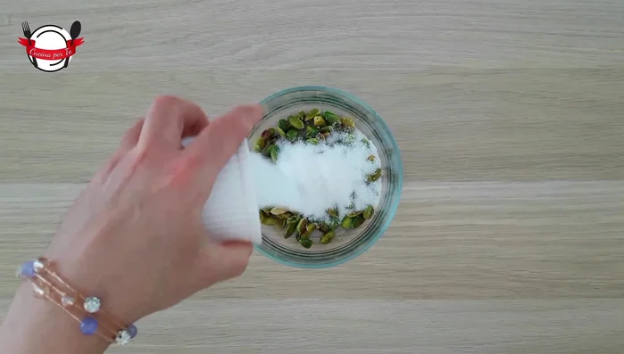 Mettere i pistacchi in una ciotola, aggiungere lo zucchero e un terzo del latte. Frullare con un frullatore ad immersione fino ad ottenere una pasta morbida e omogenea.