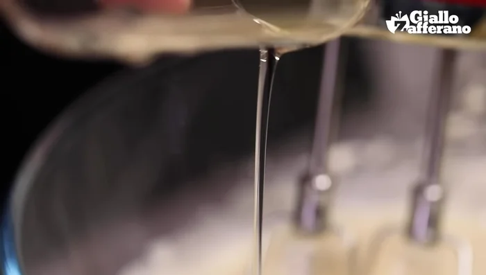 Aggiungere all'impasto montato l'olio a filo, la scorza e il succo di limone.