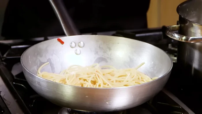 Mantecare la pasta, aggiungendo un po' di acqua di cottura se necessario. (341.08)