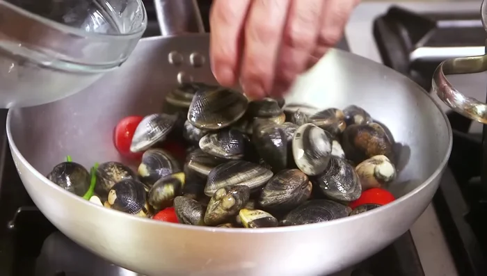 Unire le vongole nella padella calda, coprire e cuocere finché si aprono. (66.18)
