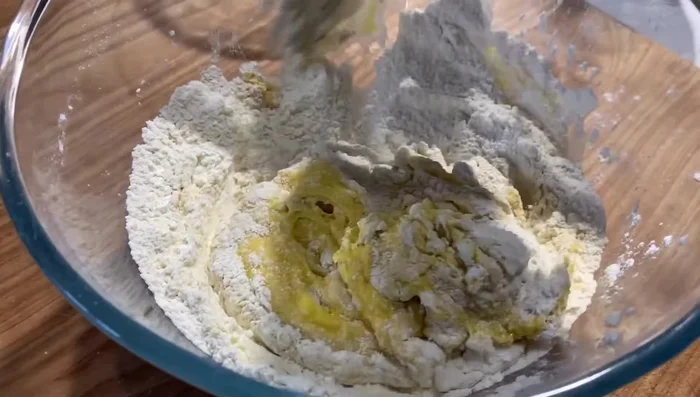 Impastare fino ad ottenere un composto liscio ed omogeneo. Avvolgere nella pellicola e lasciare riposare.