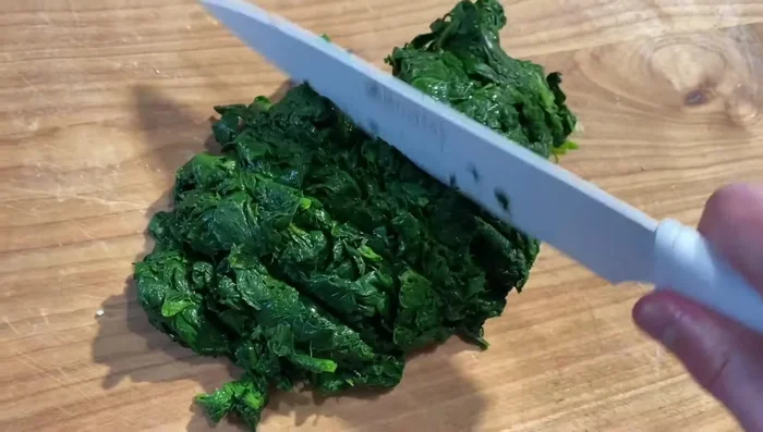 Tritare finemente gli spinaci cotti.