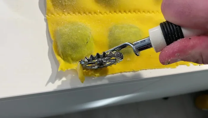 Tagliare i ravioli con la rotella tagliapasta.