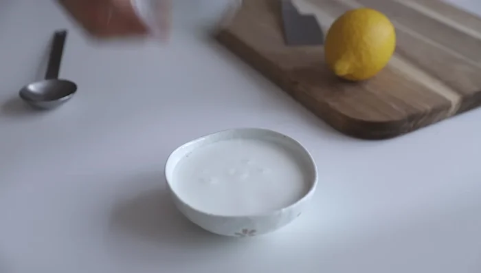 In una ciotolina, unire 150g di latte tiepido e un cucchiaio di succo di limone (si formerà il batter mills).