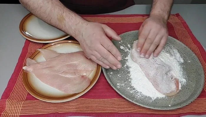 Infarinare leggermente le fettine di pollo, sbattendole per eliminare la farina in eccesso. Disponere su un piatto.