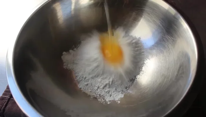Preparare la pastella: In una ciotola, mescolare la farina, l'uovo, il sale, il pepe di Caienna, la crème fraîche (o alternativa) e l'olio. Mescolare con una frusta fino ad ottenere un composto liscio e omogeneo.
