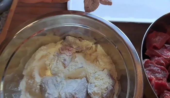 Infarinare la carne di manzo con la doppia farina per sigillarla.