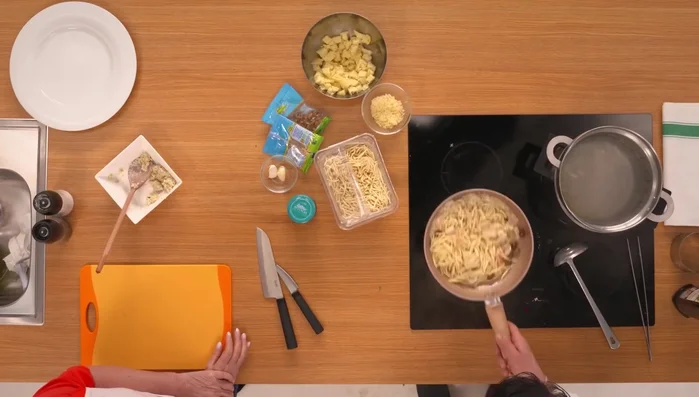 Scolare la pasta e saltarla in padella con il pesto di noci, le olive taggiasche e gli scampi.