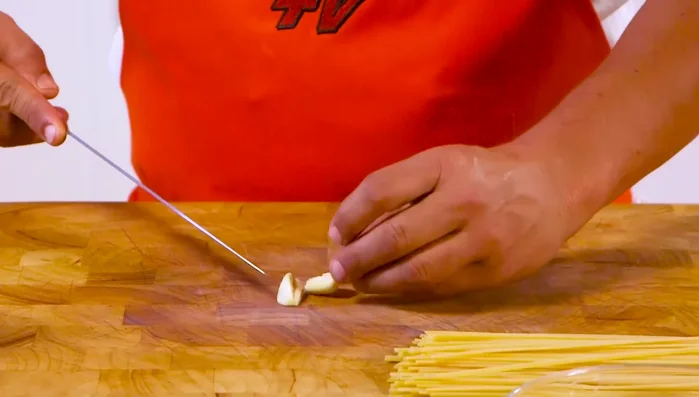 Tritare finemente uno spicchio d'aglio.