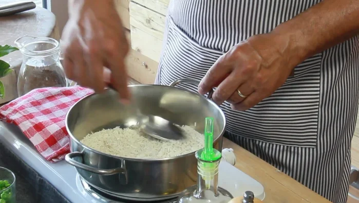 In una pentola, preparate il pilaf: fate tostare leggermente il riso con un po' di olio, sale e pepe. Aggiungete acqua fredda (circa 1 cm sopra il livello del riso), una foglia di alloro, chiodi di garofano infilzati in una cipolla, e i pisellini surgelati. Portate ad ebollizione, poi abbassate la fiamma al minimo, coprite e lasciate cuocere per circa 12 minuti senza mescolare.