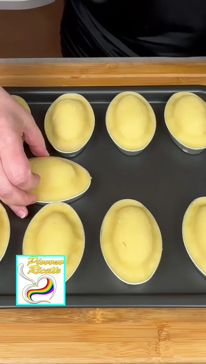 Posizionare i pasticciotti su una leccarda e spennellarli con un uovo sbattuto con un goccio di latte.