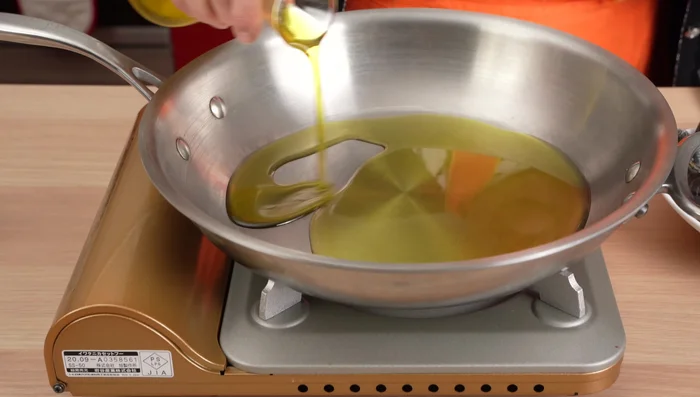 In una pentola, aggiungere abbondante olio extravergine di oliva, aglio, cipolla e peperoncino. Soffriggere per insaporire l'olio.