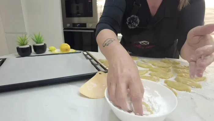 Passare i biscotti nello zucchero a velo.